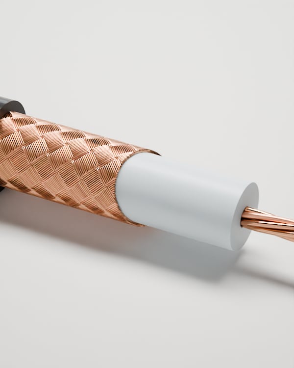 3D-Rendering: Detail der abgesetzten Lagen – Koaxialkabel RG 213 mit schwarzem Mantel, Kupfergeflecht, weißer Isolierung und verseiltem Kupferleiter, im Fotostudio auf hellem Grund, Aufdruck „Cable Creations“